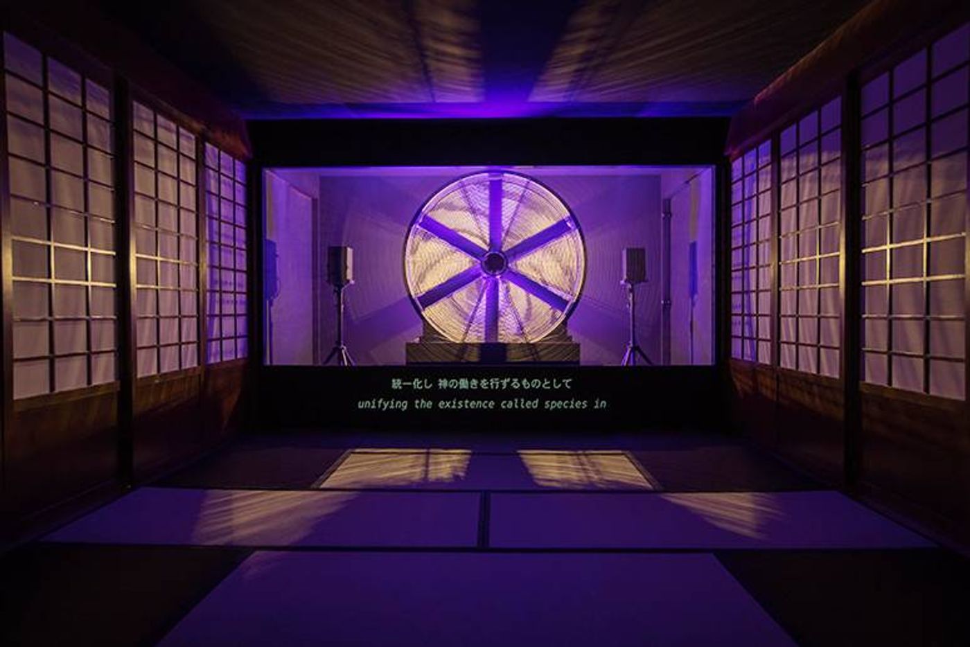 Installation view of Ho Tzu Nyen’s Hotel Aporia: a glowing wheel projected in a tatami room with shoji screens