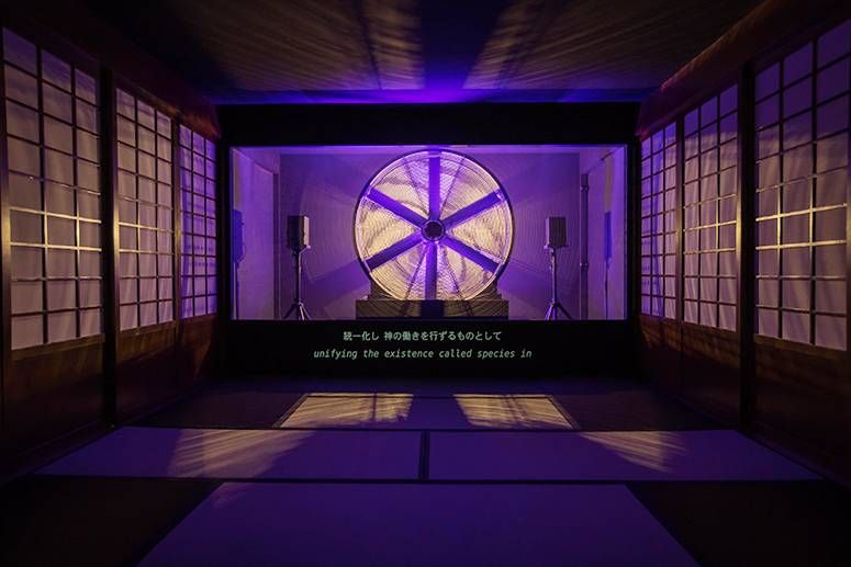Installation view of Ho Tzu Nyen’s Hotel Aporia: a glowing wheel projected in a tatami room with shoji screens