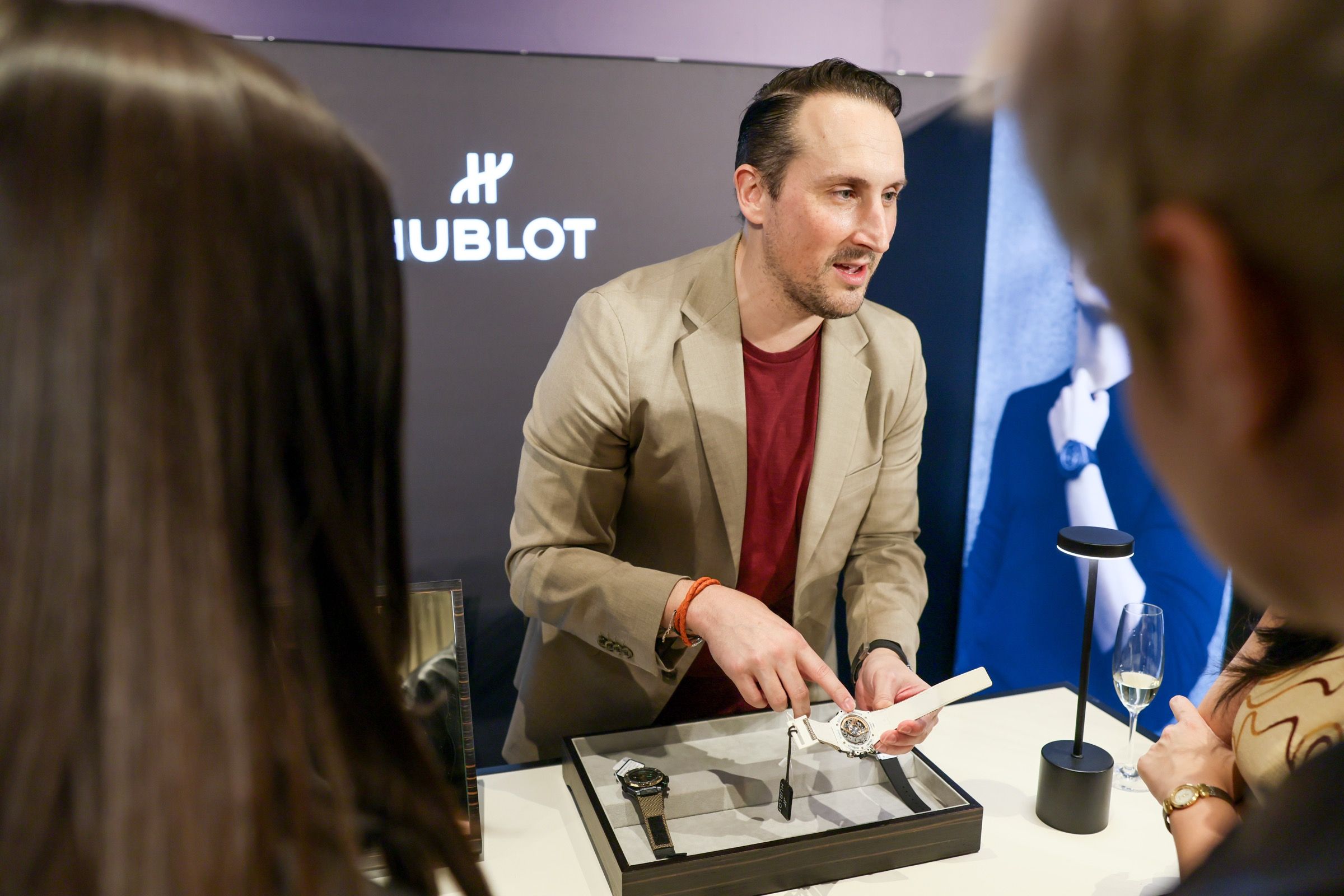 A Hublot representative pointing out movement details on a white strap watch at Lucerne Watch Week