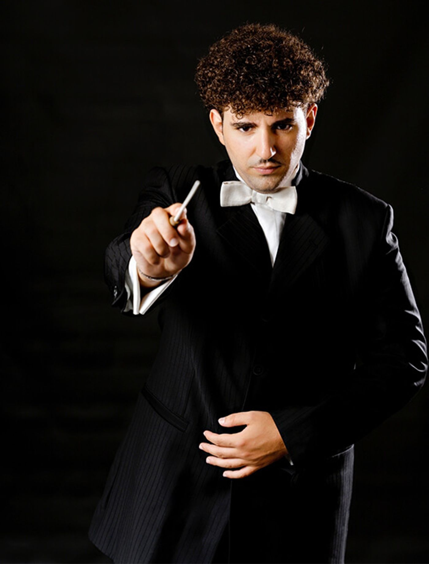 Musical director Mariano Panico standing in front of a microphone and speaking during a masterclass