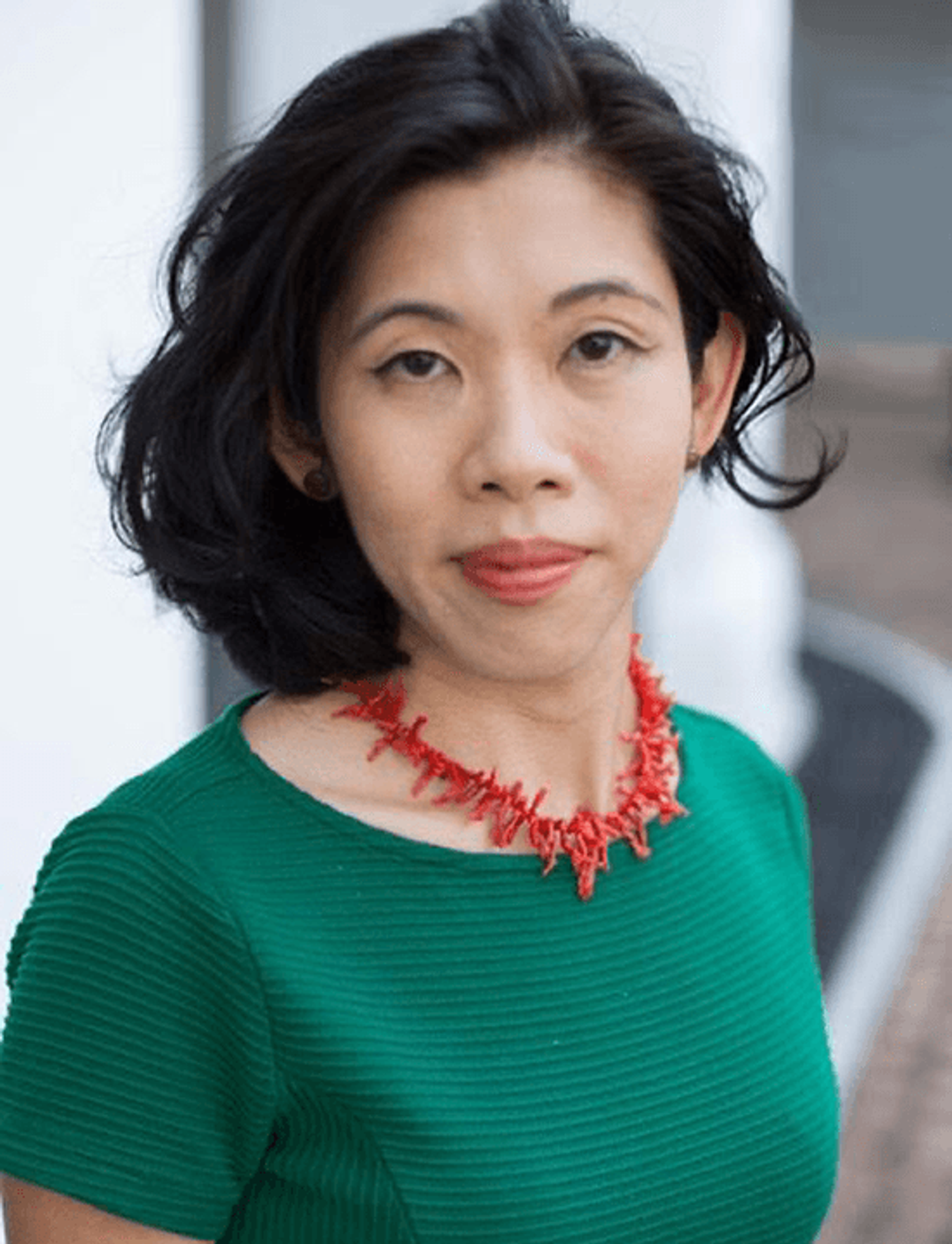 Curator Joyce Toh in a green top and red coral necklace, her dark bob framing her face