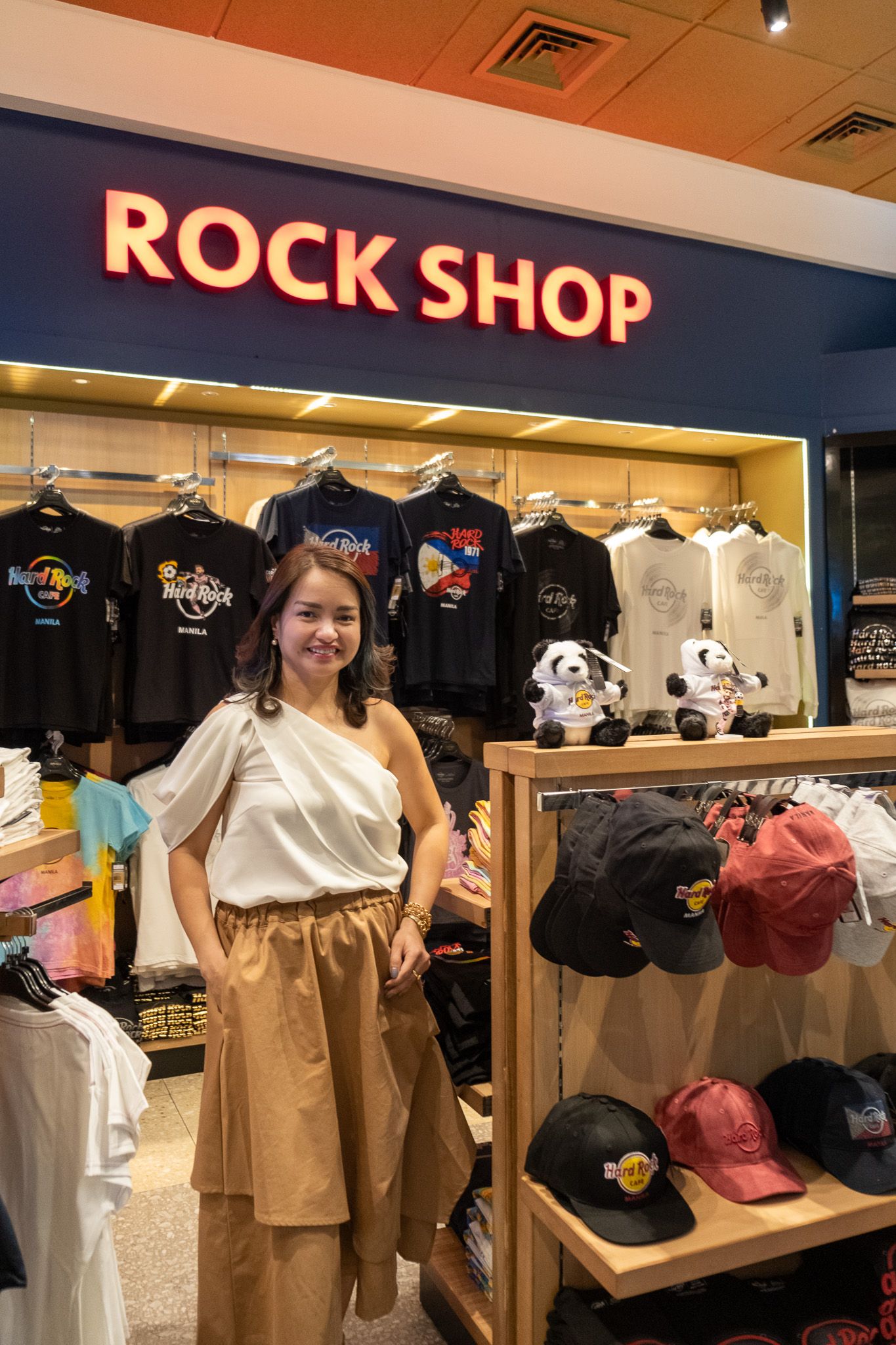 RC Tiongson, chief operating officer of The Bistro Group, standing in the Hard Rock Café Rock Shop among band tees and caps