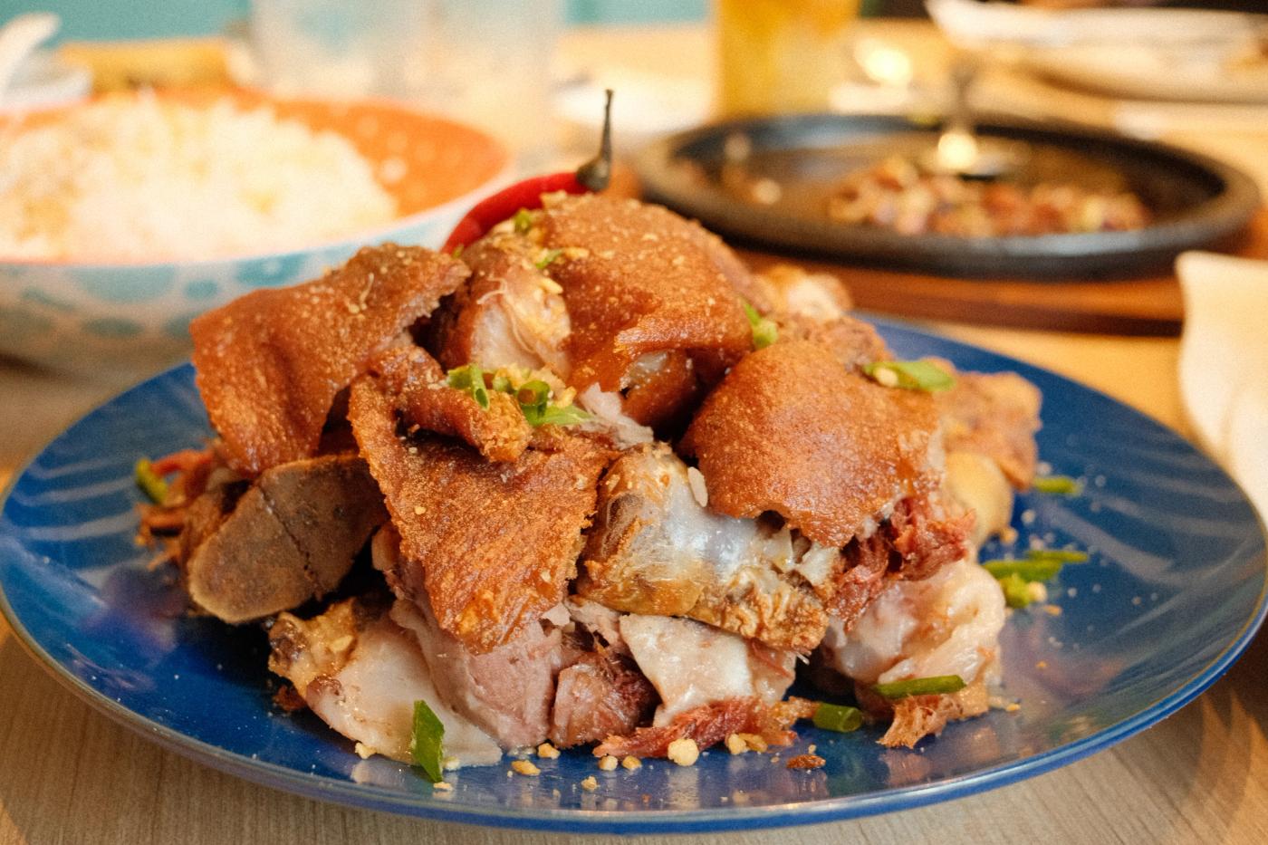 Crispy Pata-rrific: golden shards of crackling pork knuckle piled high on a blue plate