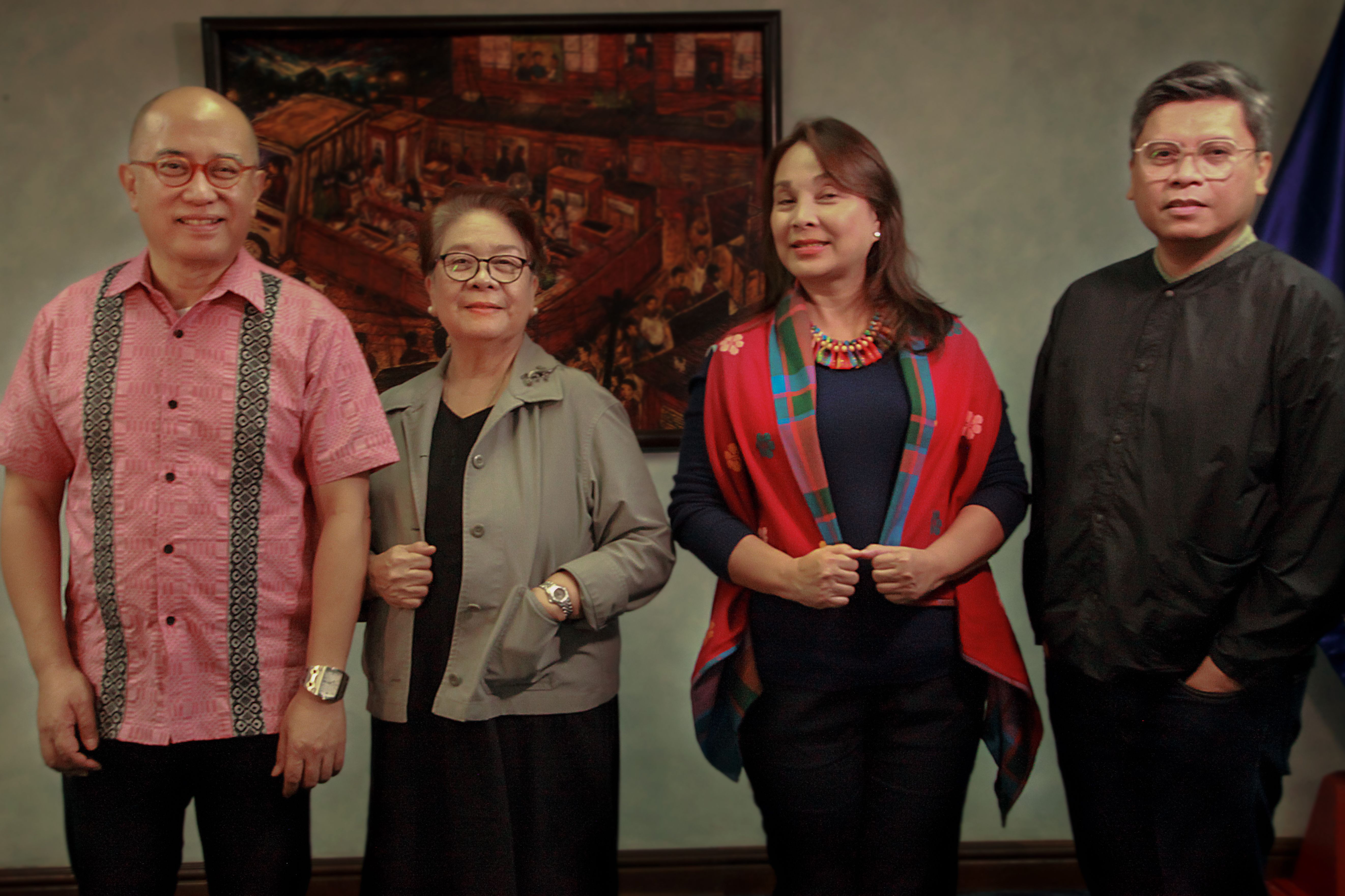 Jurors of the Philippine Pavilion for the 60th Venice Biennale standing and sitting together in a conference room during deliberations