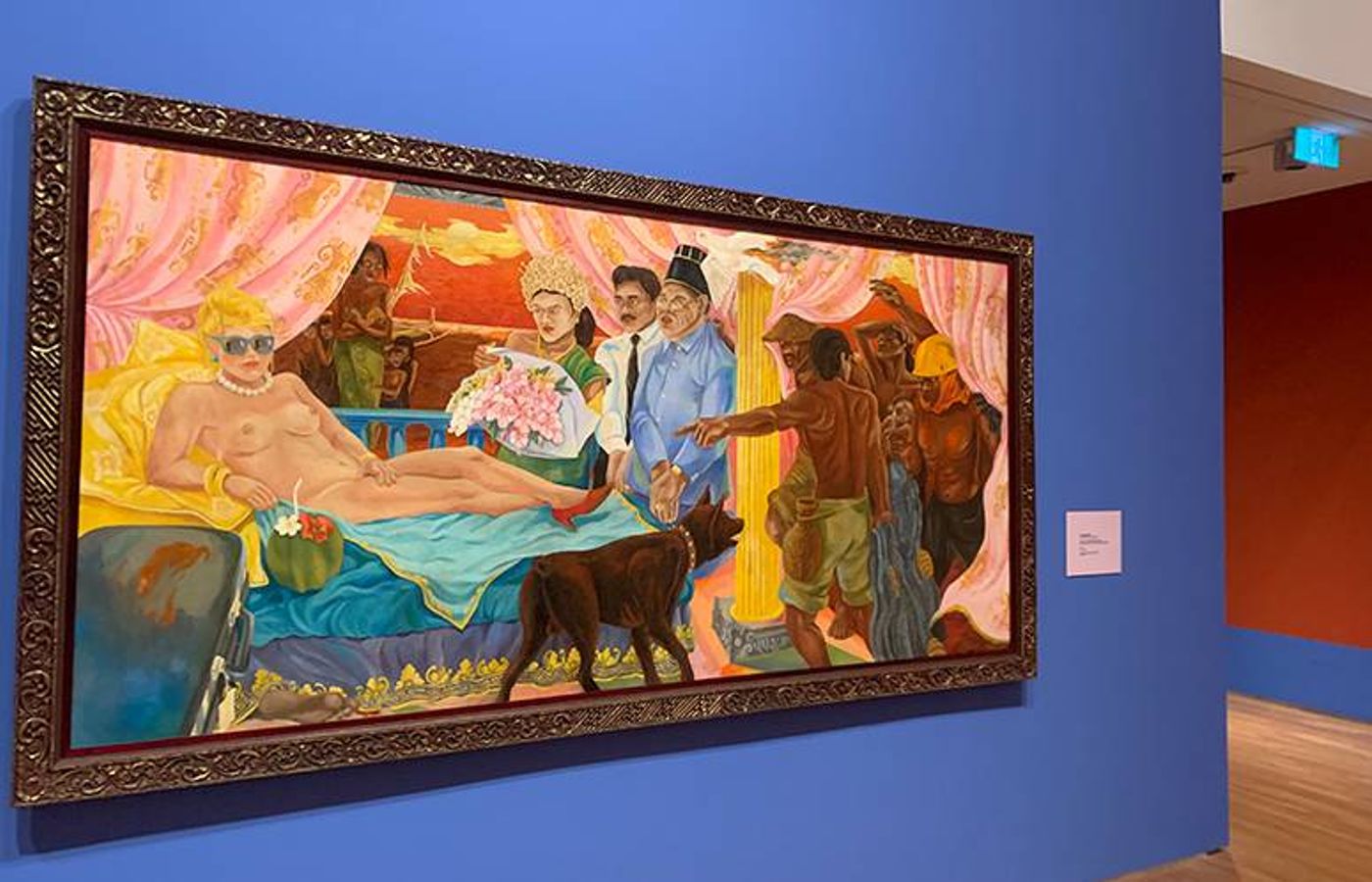 Semsar Siahaan’s Olympia painting: a reclining pale figure attended by onlookers, in an ornate frame