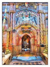 Candles and ornate lamps crowd the marble entrance of the Aedicule enclosing the tomb