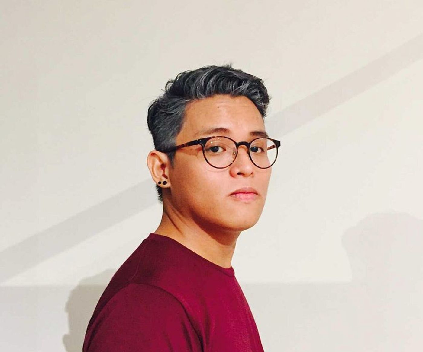 Portrait of Carlos Quijon Jr., curator of the Philippine Pavilion, posing in a dark room