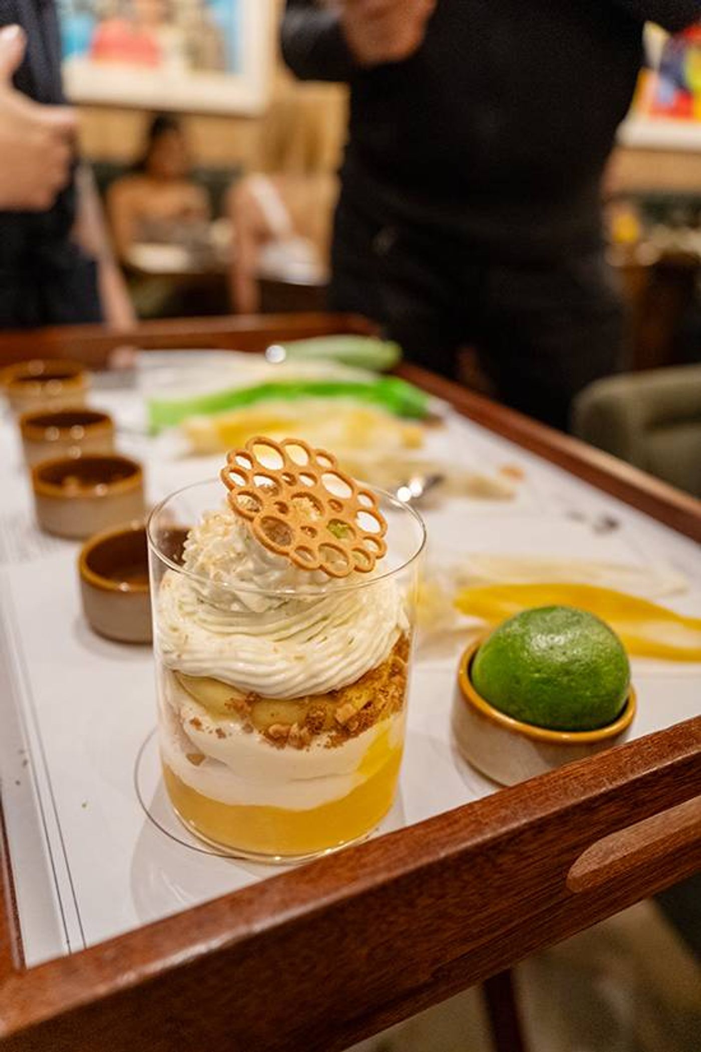 Mango Knickerbocker parfait layered with cream and crumble, crowned with a lattice biscuit