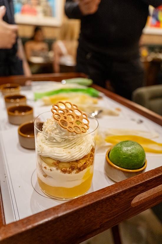 Mango Knickerbocker parfait layered with cream and crumble, crowned with a lattice biscuit