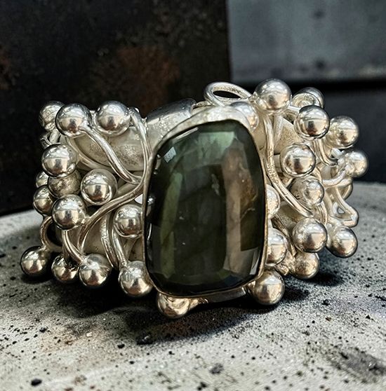 Silver cuff by Michelline Syjuco clustered with silver beads around a large labradorite stone