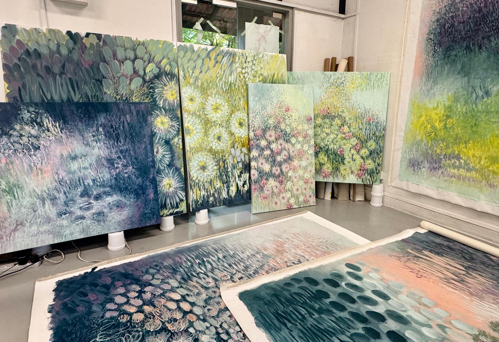 Canvases of layered botanical abstractions stacked in Maria Tan’s Singapore studio, two unstretched works on the floor