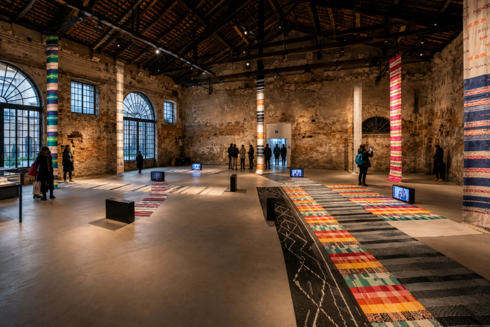 Weaving installation with red threads and textiles hanging from the rafters of the Arsenale during the Philippine Pavilion exhibition at the Venice Biennale