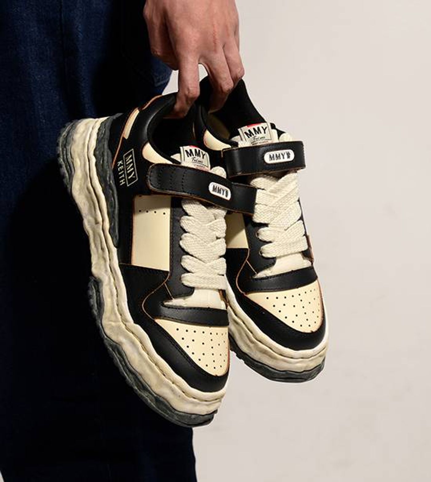 Side-by-side view of classic black and white Maison Mihara Yasuhiro Keith OG canvas low-top sneakers with deconstructed wavy soles