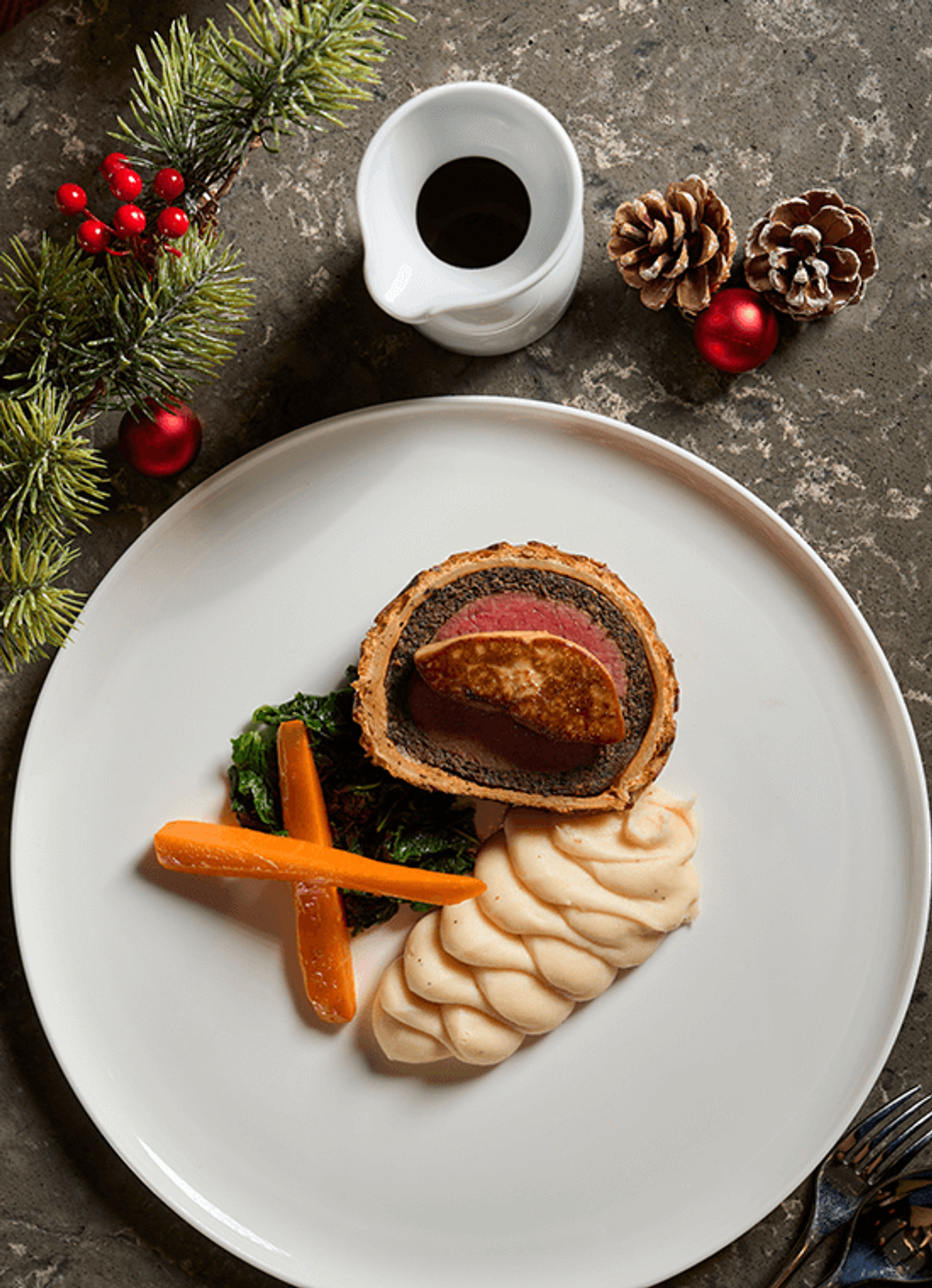 Beef Wellington Rossini with foie gras, piped mash and carrots, ringed by pine sprigs and baubles