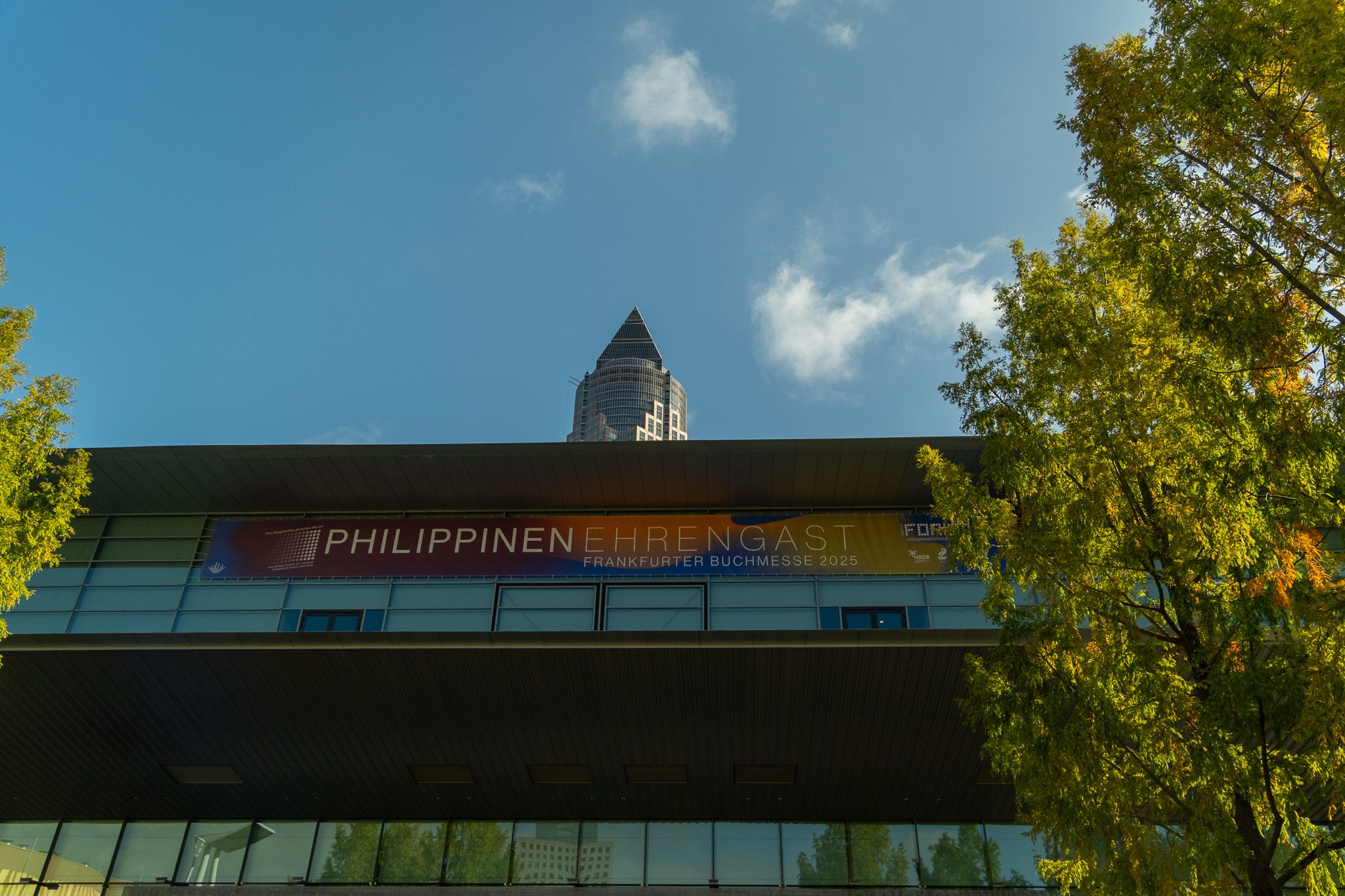 Philippinen Ehrengast banner on the Frankfurt fair hall with the Messeturm tower rising behind