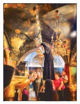 A nun on a ladder tends hanging oil lamps inside the Church of the Holy Sepulchre