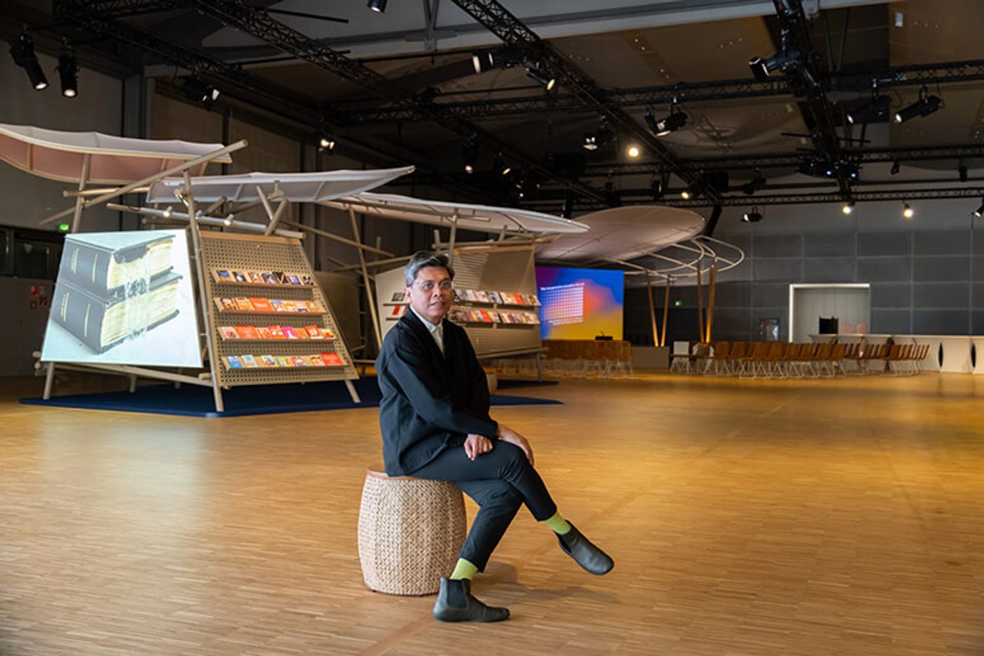 Curator Patrick Flores seated on a woven stool inside the Philippine Pavilion’s exhibition hall