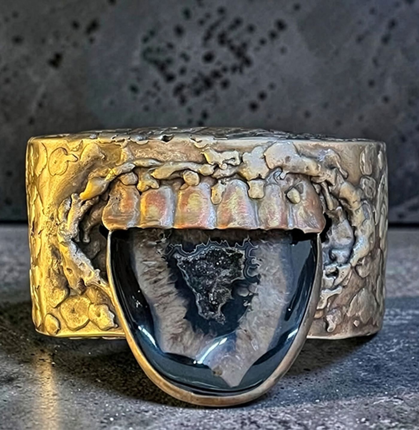 Oxidized silver cuff by Michelline Syjuco sculpted as an open mouth with an agate stone for a tongue