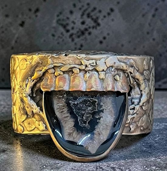 Oxidized silver cuff by Michelline Syjuco sculpted as an open mouth with an agate stone for a tongue