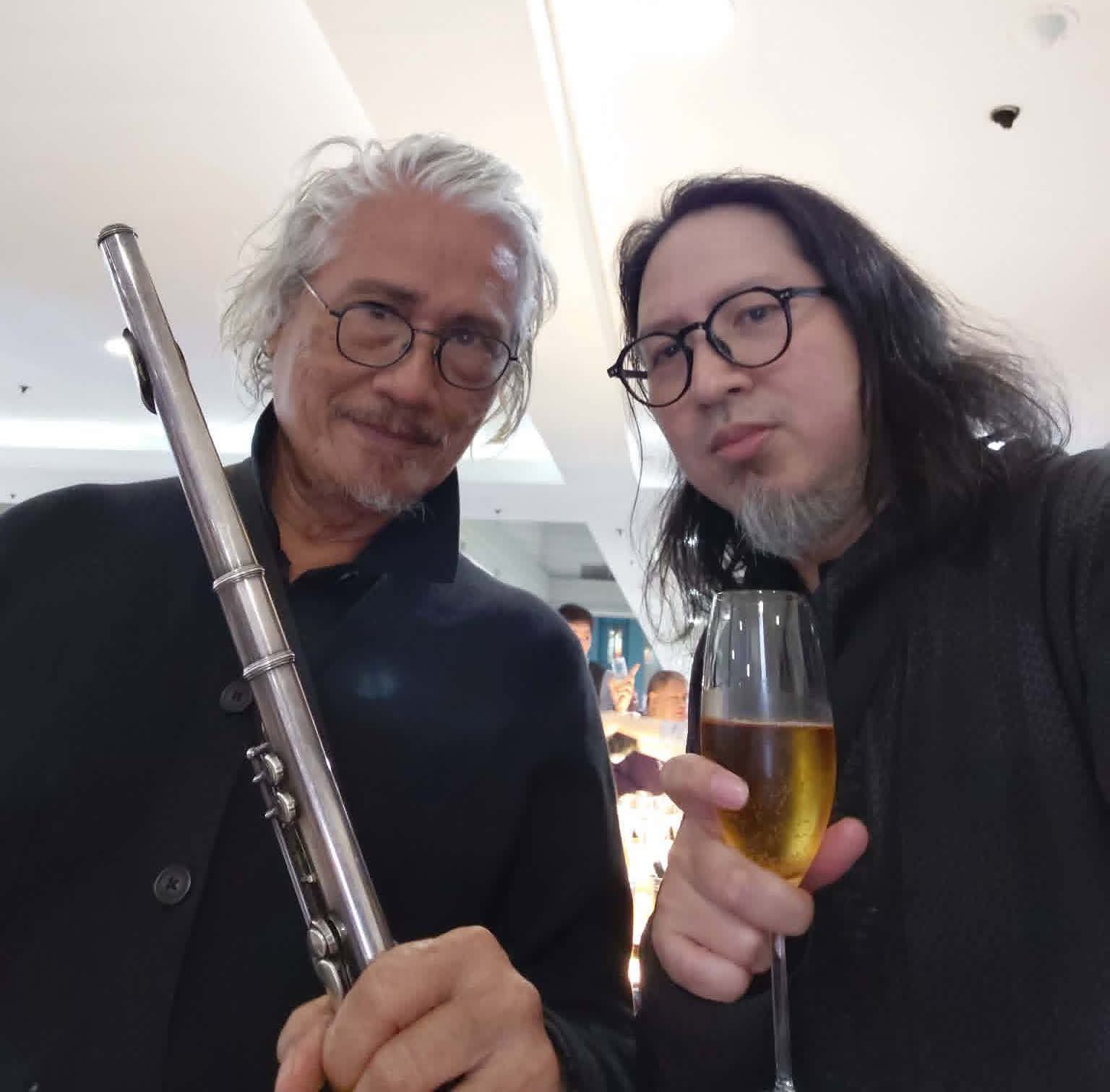 Gus Albor holding a flute beside Julius Sanvictores raising a glass at the Sorceress opening