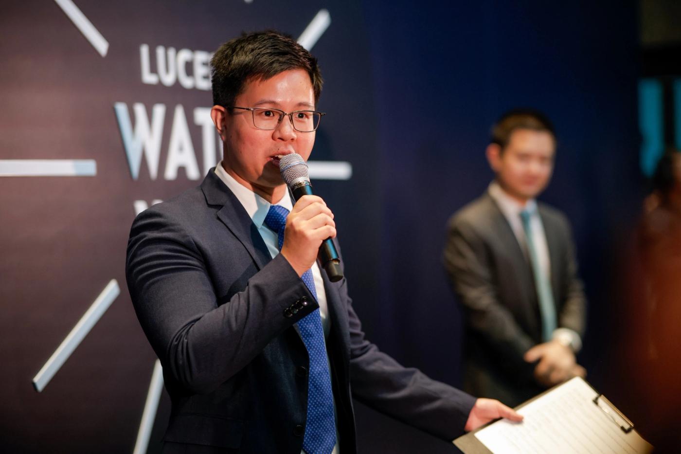 Mark Yao speaking into a microphone during opening remarks at Lucerne Watch Week