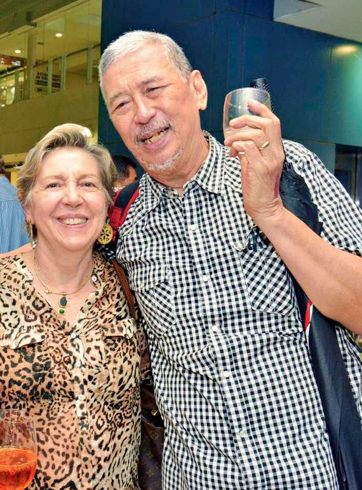 Gallerist Silvana Diaz in a leopard-print blouse with artist Jose Tence Ruiz raising a cup at the Sorceress opening