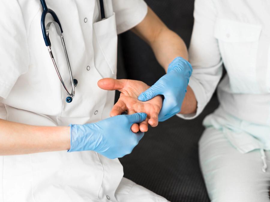 Rheumatologist examining a patient's hand joints during a clinical assessment for autoimmune disease