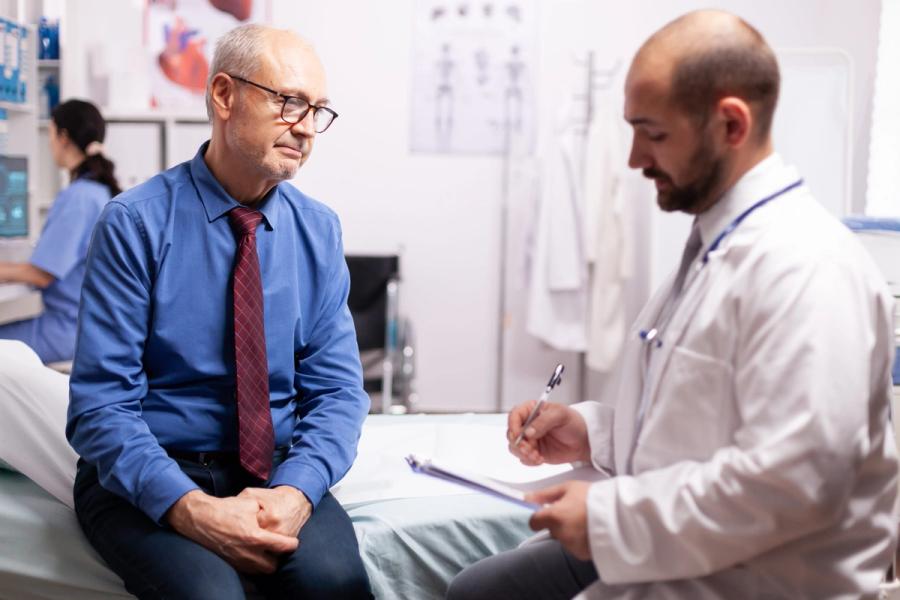 Doctor reviewing colon cancer screening status with a patient, showcasing follow-up coordination and ongoing documentation