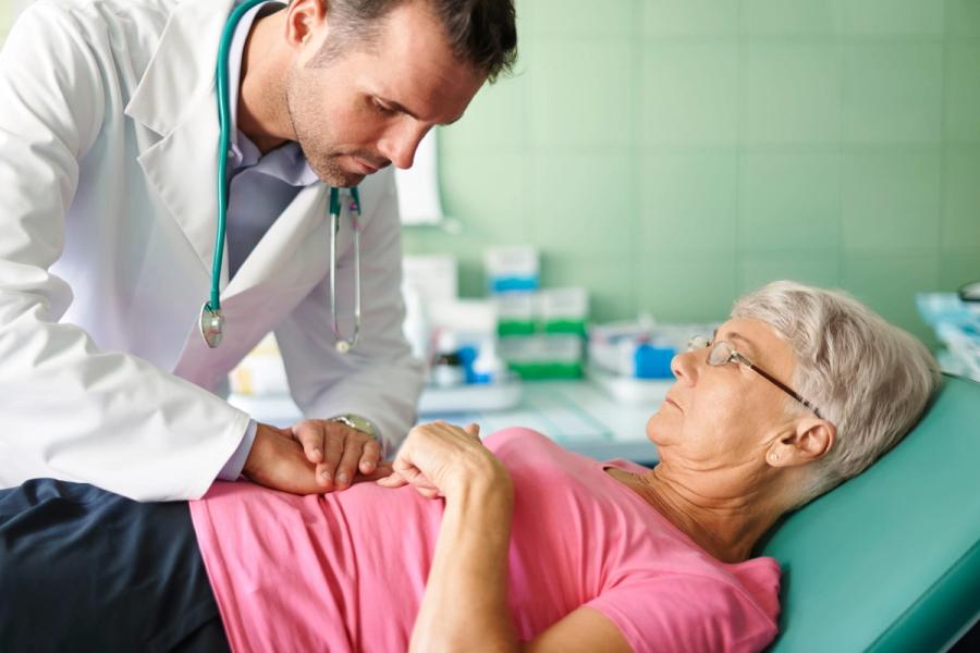 Doctor performing an abdominal exam, part of post-screening follow-up to address potential concerns and schedule further diagnostics.