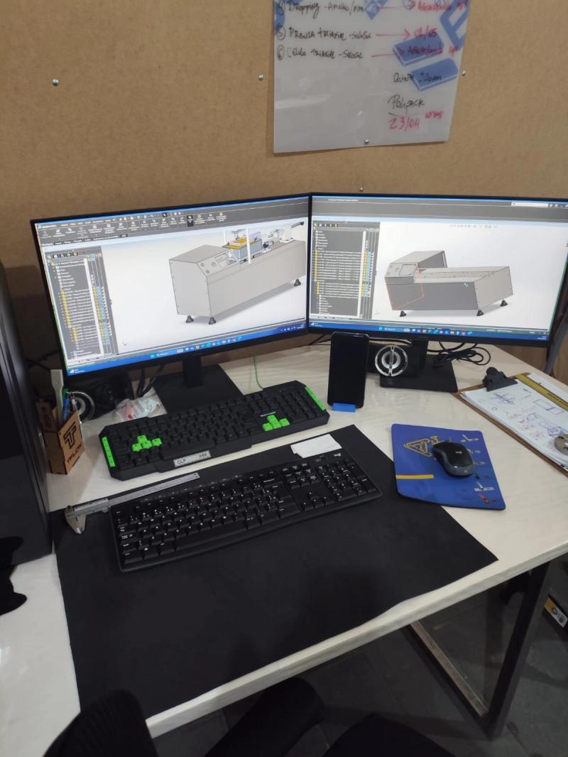 Estação de projeto da GRD com o modelo 3D da máquina aberto nas três telas