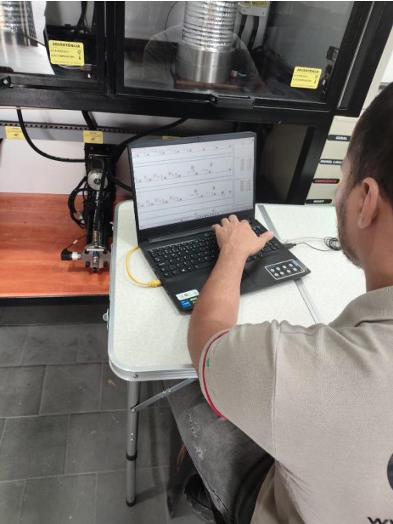 Técnico da GRD conduz um ensaio pelo programa, no notebook ao lado da máquina