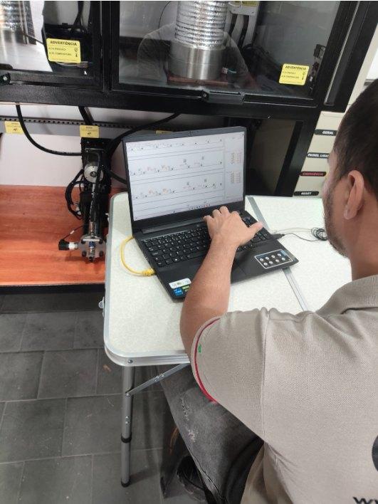 Técnico da GRD conduz um ensaio pelo programa, no notebook ao lado da máquina