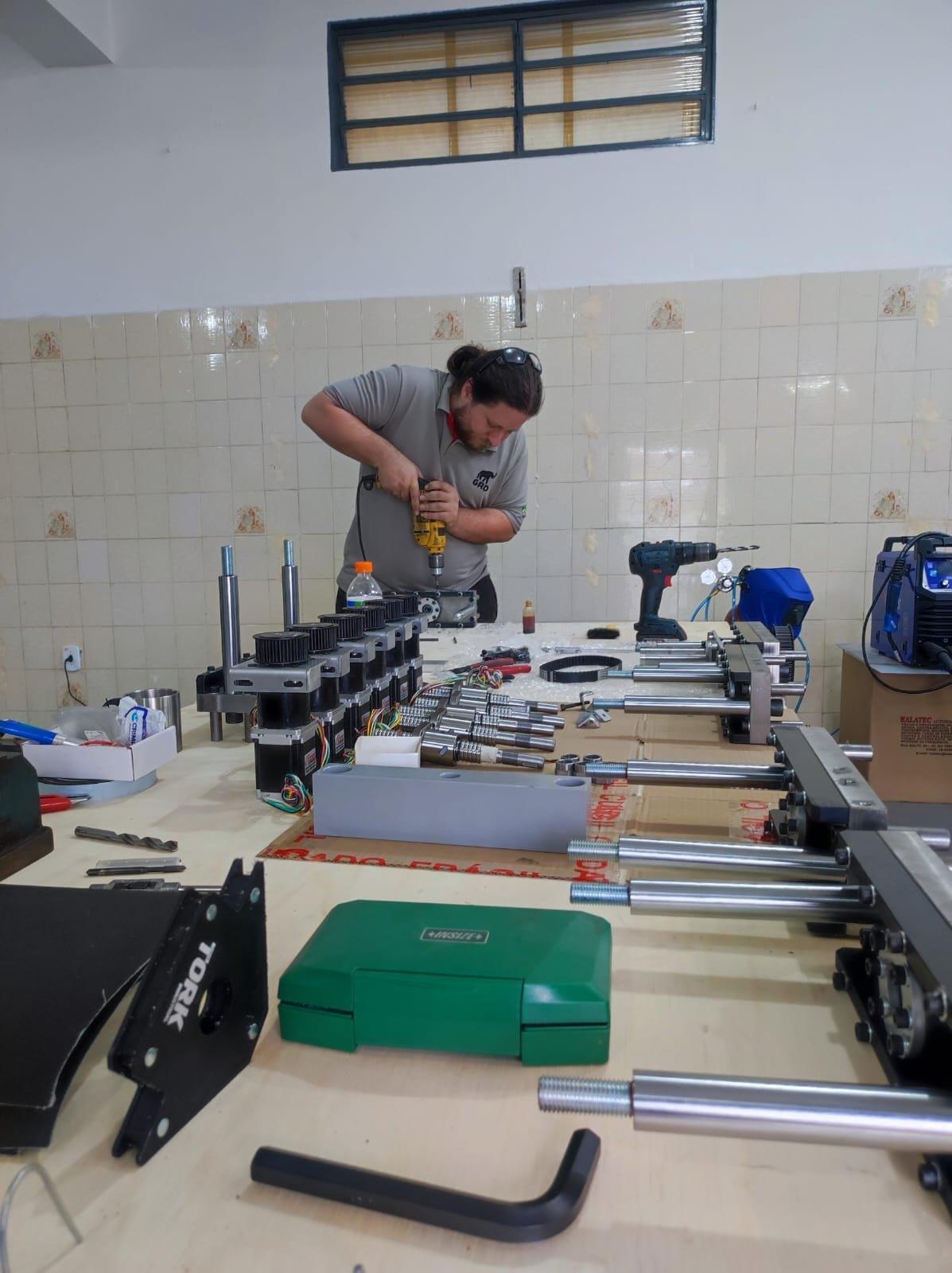 Técnico da GRD monta os componentes de uma máquina de ensaio na bancada