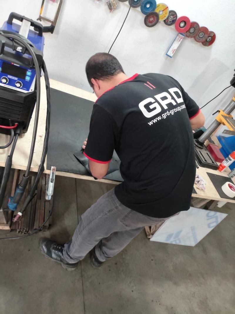 Técnico de uniforme da GRD trabalhando na bancada de montagem