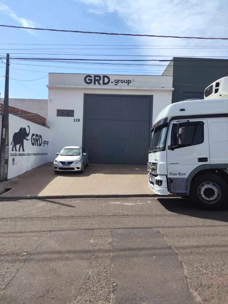 Caminhão carregando na porta da GRD, com a fachada ao fundo