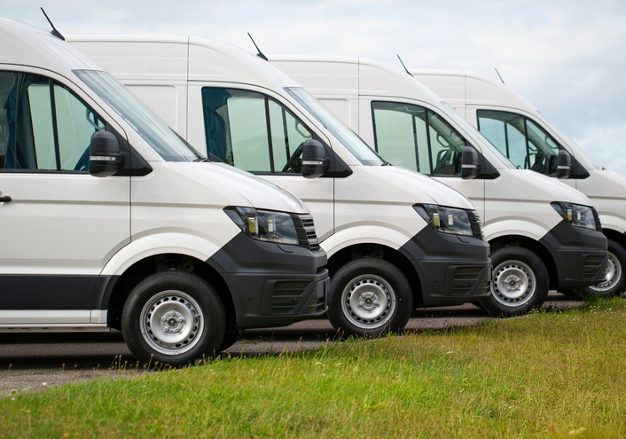 Row of 4 white parked vans