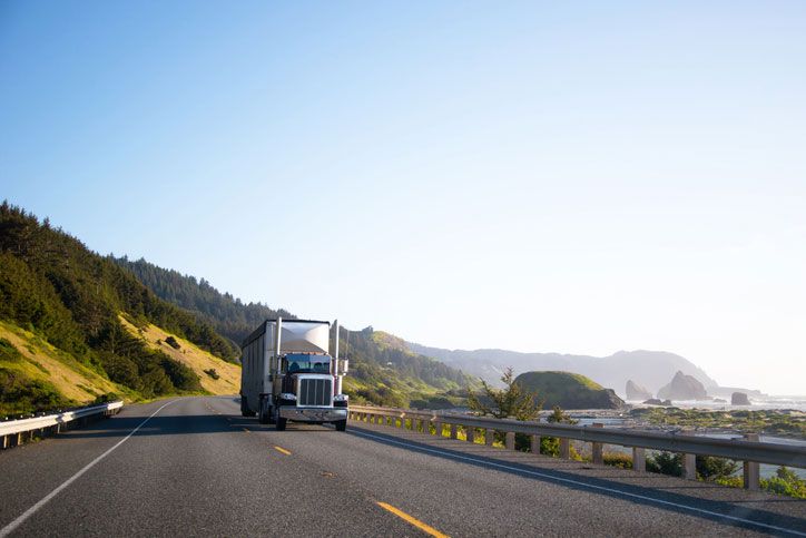 Large truck driving down ocean side road