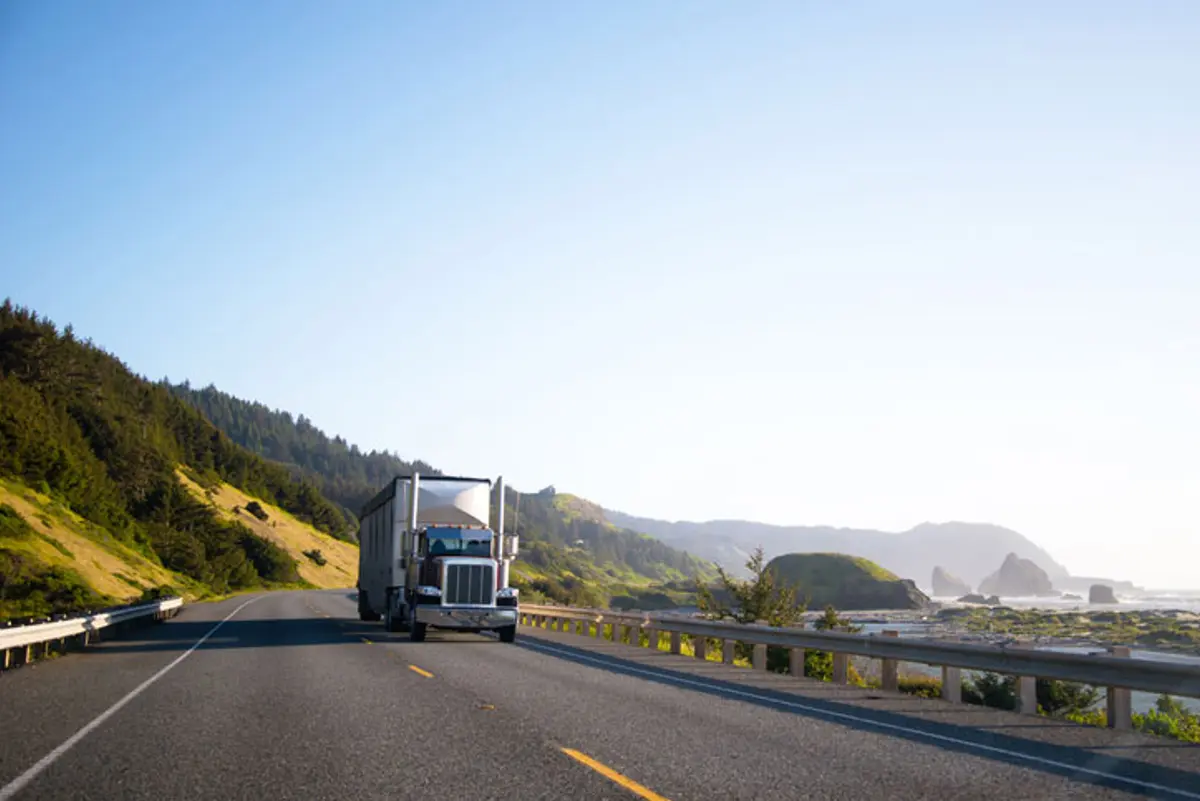 Large truck driving down ocean side road