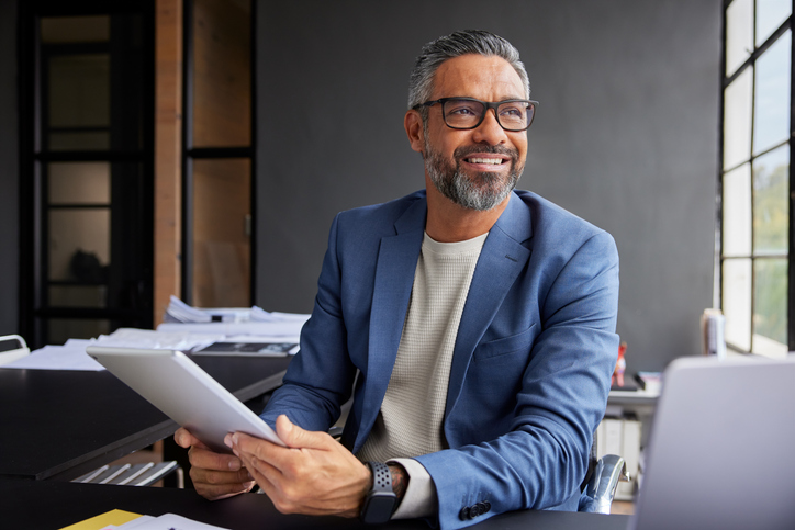 Businessman smiling, looking out window