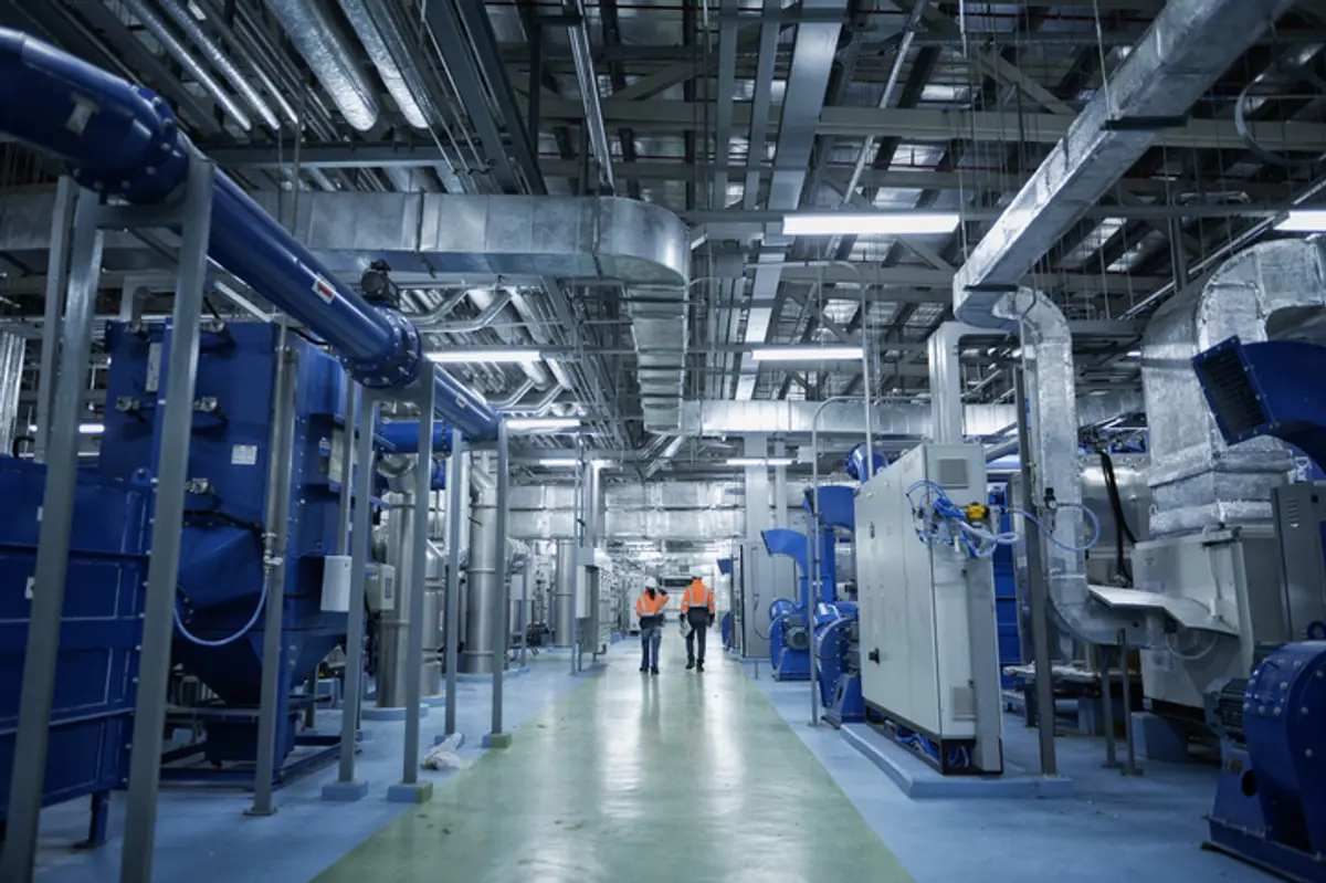 two trades people in machine room