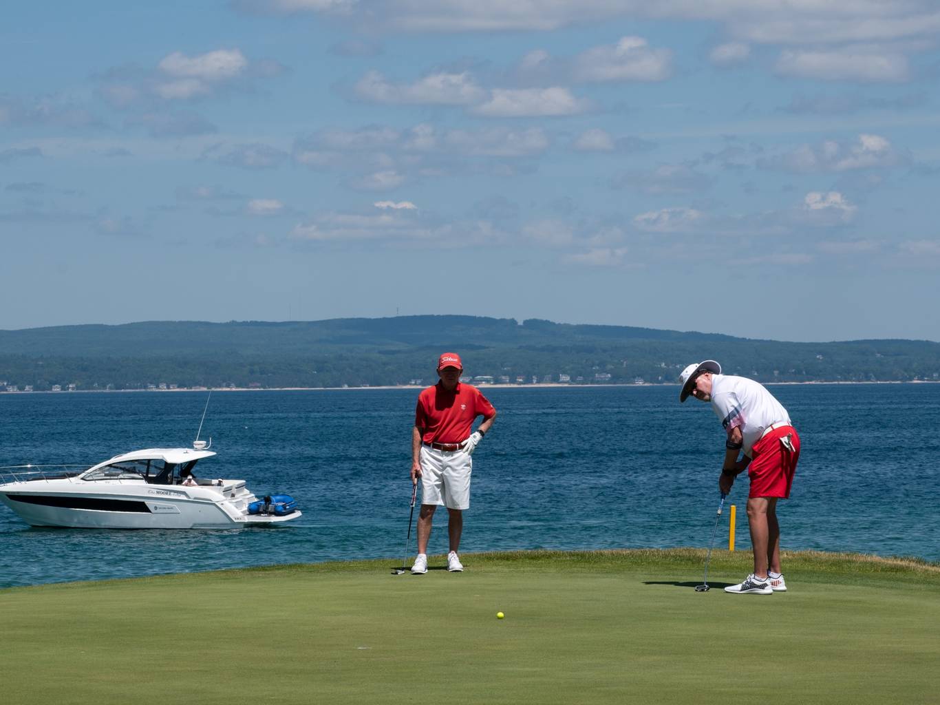 guys on green with lake in background