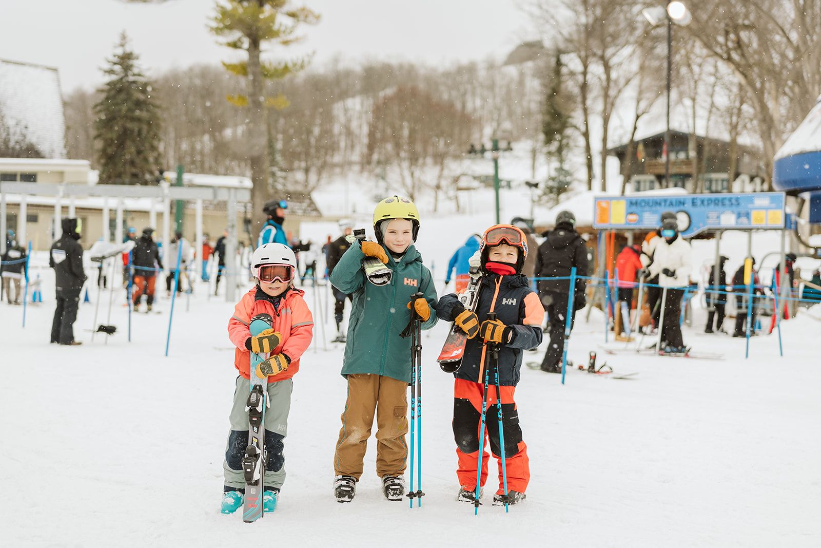 Children in ski gear holding their skis and posing at Boyne Mountain