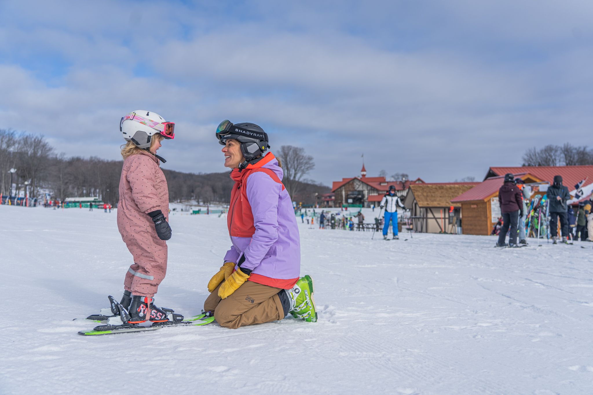 woman kneeling to young skier