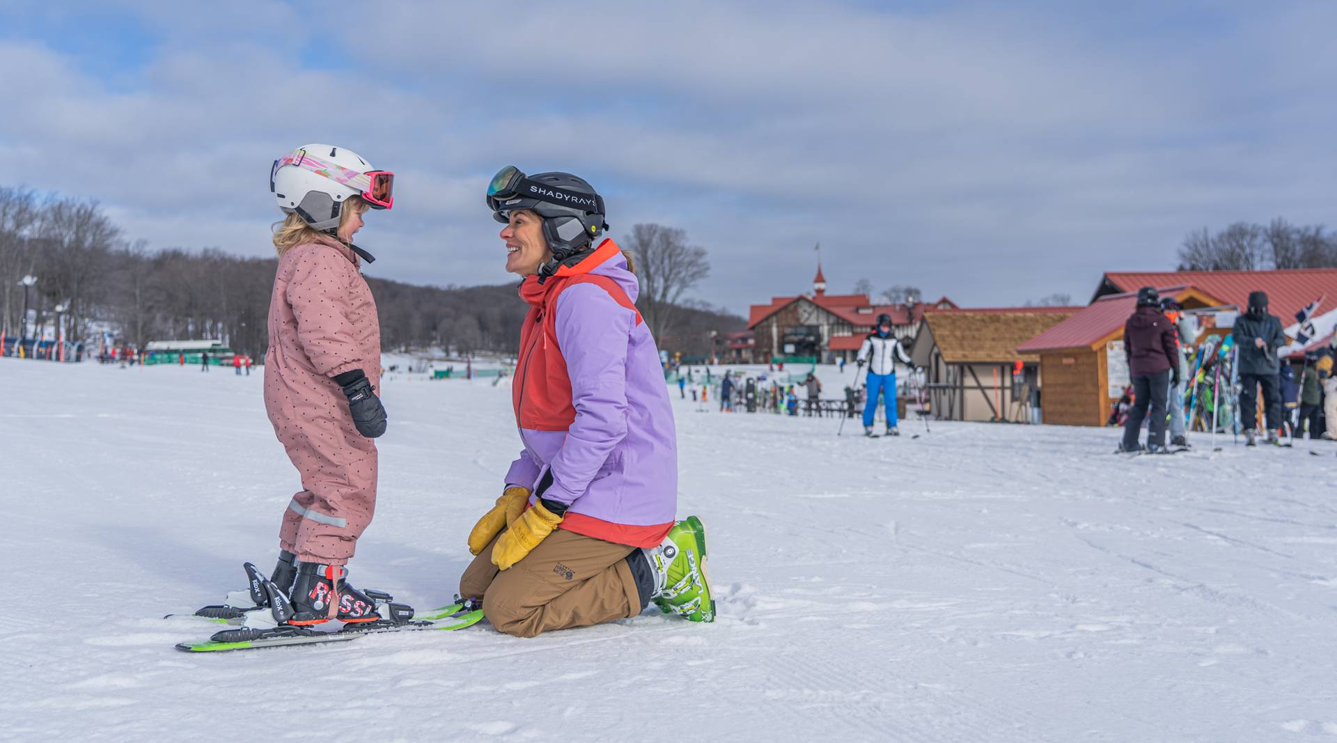 woman kneeling to young skier