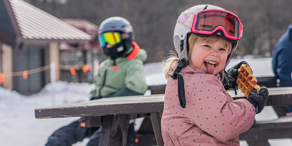 little girl eating Waffle Cabin sticking out tongue