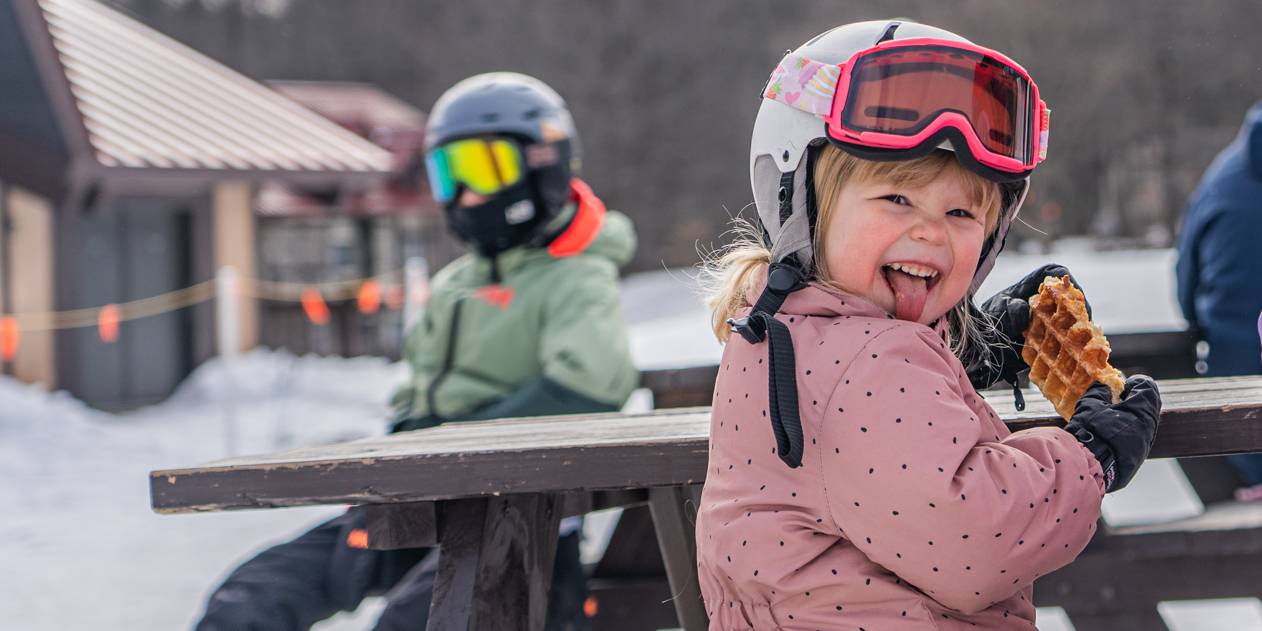 little girl eating Waffle Cabin sticking out tongue
