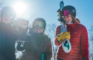 girls carrying skis