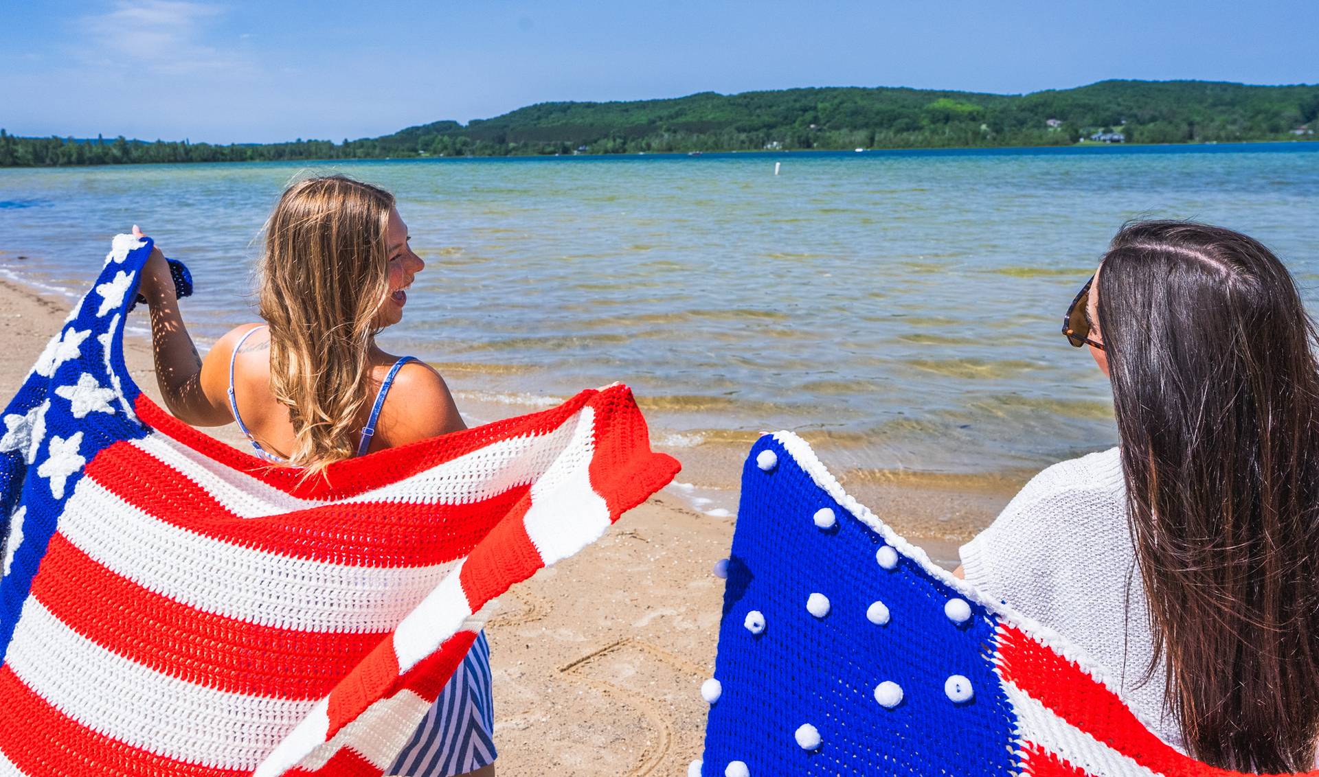 girls with american flags at the beach