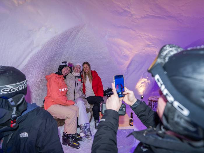 girls taking photo inside iglu