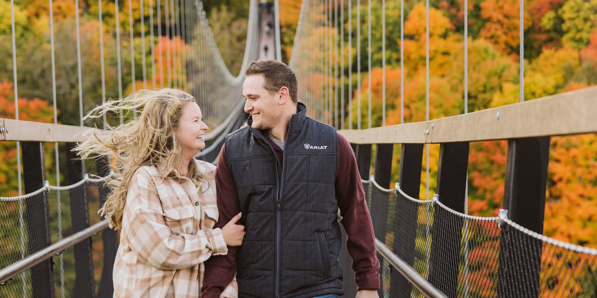 Couple on Skybridge with fall colors in the background